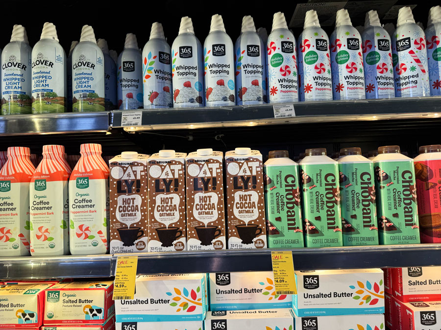 365 by Whole Foods Market butter, whipped toppings, and seasonal coffee creamers on grocery store shelves.