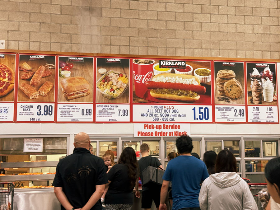 Costco food court menu featuring Kirkland Signature branding, hot dogs, pizza, sandwiches, and desserts with prices.