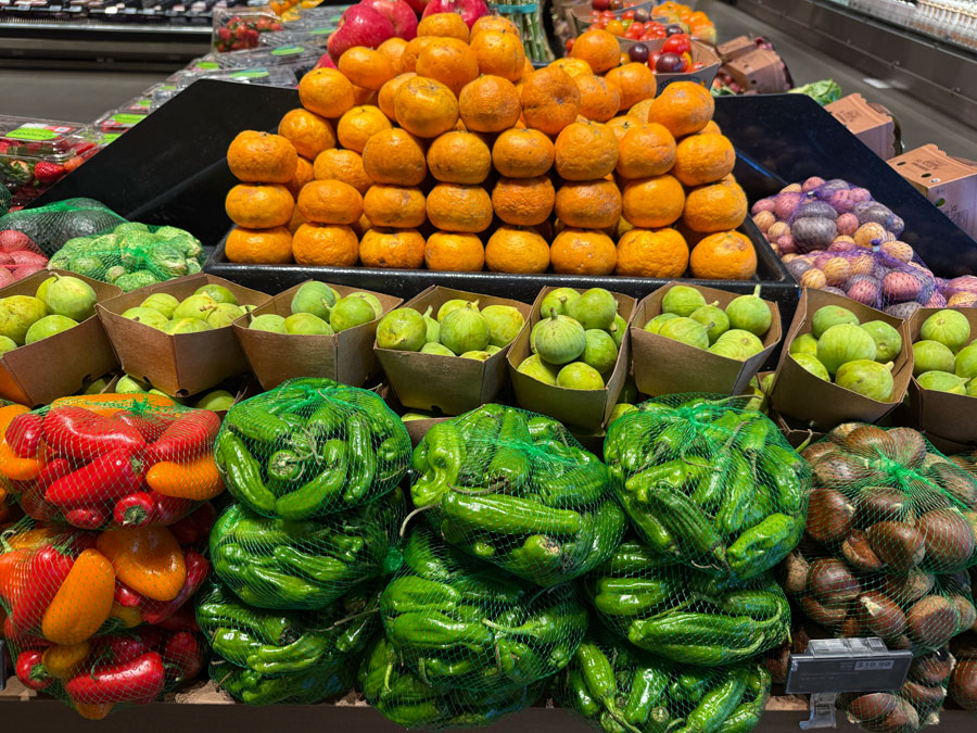Fresh citrus fruits, green figs, and peppers displayed at Erewhon.