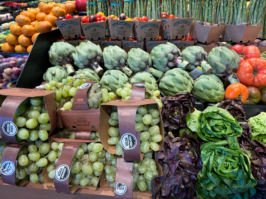 Organic grapes, artichokes, tomatoes, and leafy greens at Erewhon Manhattan Beach.