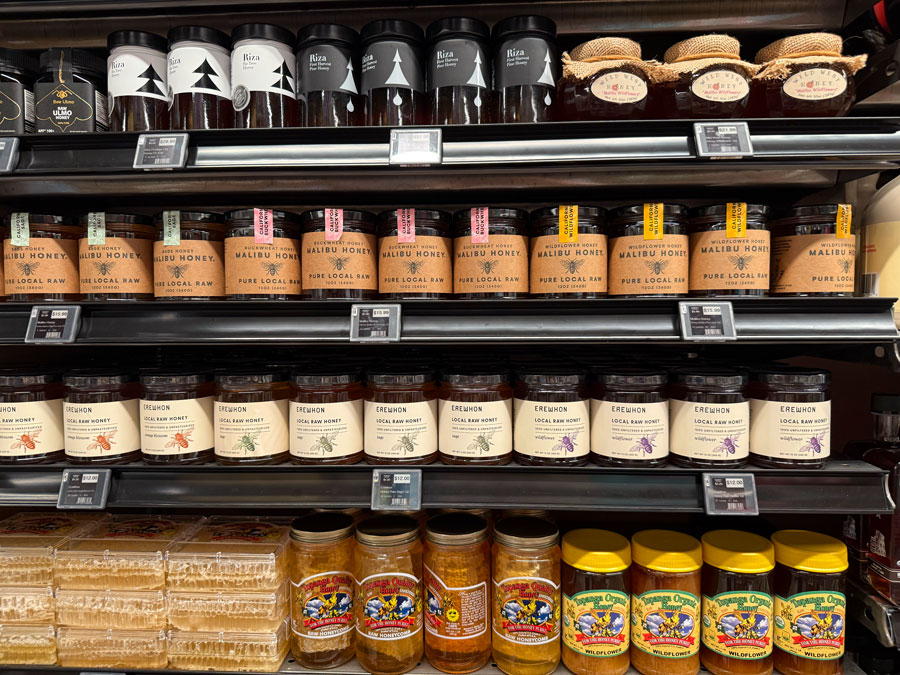 Erewhon raw honey, Malibu Honey, and specialty honey jars on store shelves.